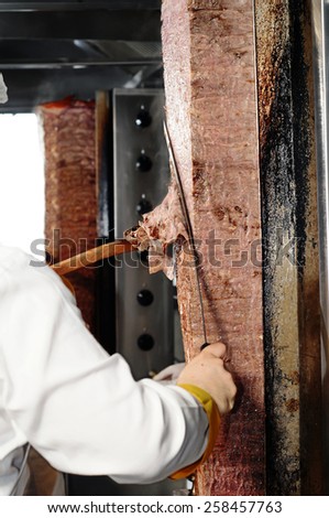 A chef cutting traditional Turkish food Doner Kebab in the restaurant