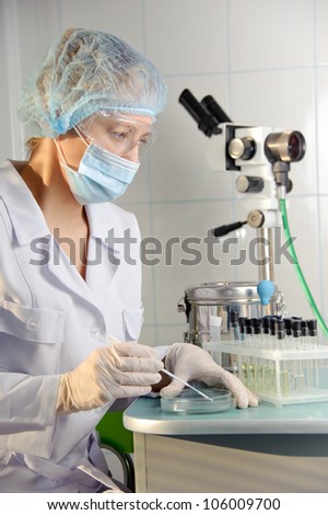 A female doctor examines a sample.  Could be useful for medicine, hospital, research and development, clinical studies, forensics, science etc
