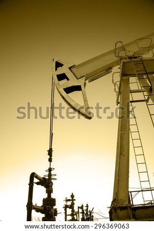 Pump jack and wellheads. Extraction of oil. Toned sepia.