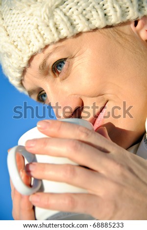 portrait of adult women in white, with mug in his hands, bright sunny frosty day