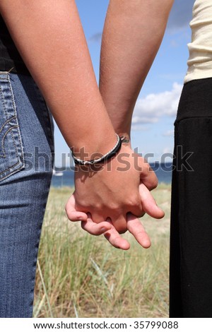 two girls holding hands at the beach