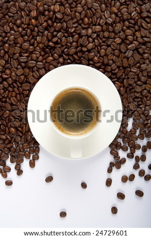 A cup of fragrant coffee in the coffee beans on