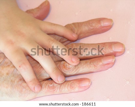 Child's hand over older hand