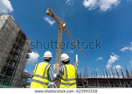 Civil engineer checking work with walkie-talkie for communication to management team in the construction site
