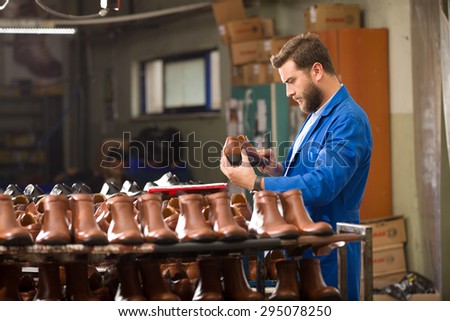 Young man working in shoes factory.