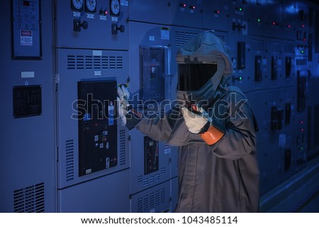 Engineer wear a arc flash protection suit for inspection electrical current \
 and checking status switch gear electrical energy distribution substation.