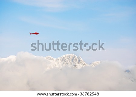 Rescue helicopter above snow peaks