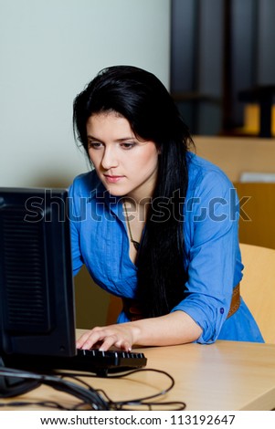 woman is working on the personal computer at the library