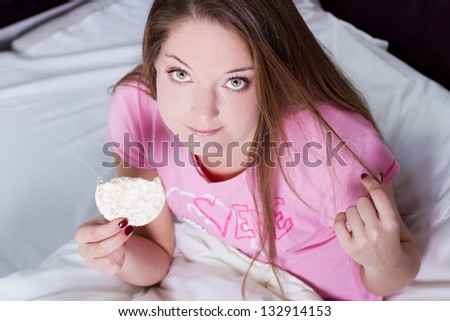 diet woman eating on her bed - top view