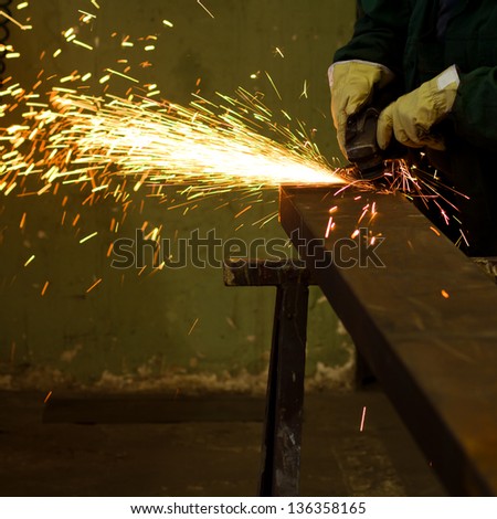 factory worker using electric grinder