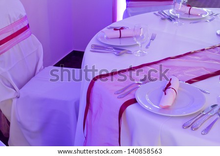 table set for wedding or another catered event dinner - purple light decoration
