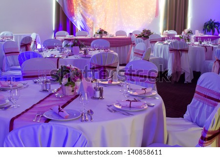 table set for wedding or another catered event dinner - purple light decoration