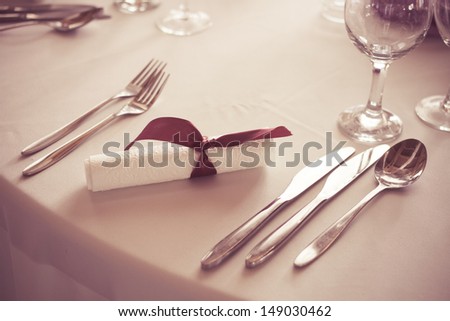 wedding or dinner table place setting, fork, spoon and knife in elegant setting - colorized photo