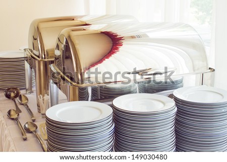 metal kitchen equipments and plates on the table for fine wedding dining or another catered event