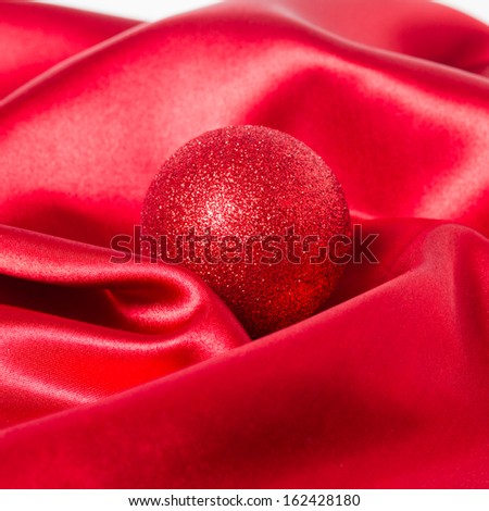 red christmas ball on a red silk cloth