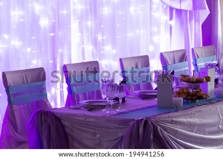 an image of tables setting at a luxury wedding hall - purple lights