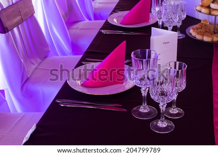 an image of tables setting at a luxury wedding hall - purple lights