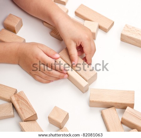 hand make a building of wooden toy blocks