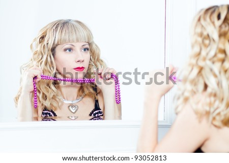 portrait of an attractive young woman standing next to the mirror