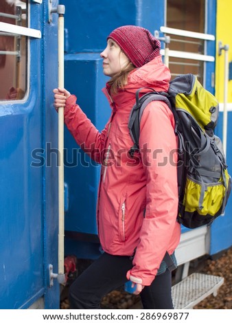 Young woman with a backpack sits on the train.
