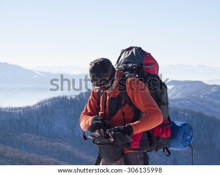 Man with glasses and a backpack hides the camera in the bag.