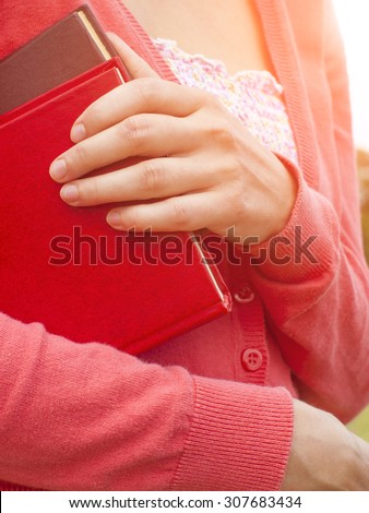 Woman autumn jacket holds educational books.