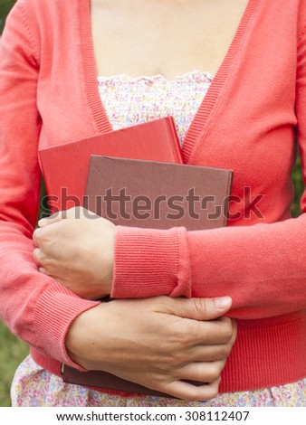 Woman autumn jacket holds educational books.