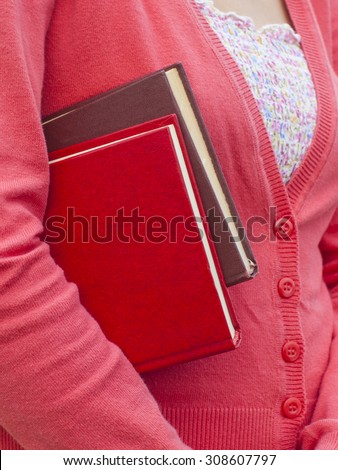 Woman autumn jacket holds educational books.