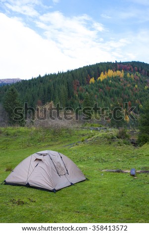 Tent for outdoor recreation stands in a clearing.