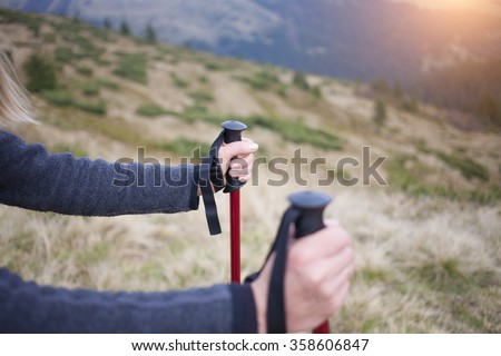 People holding Hiking sticks in the mountains.