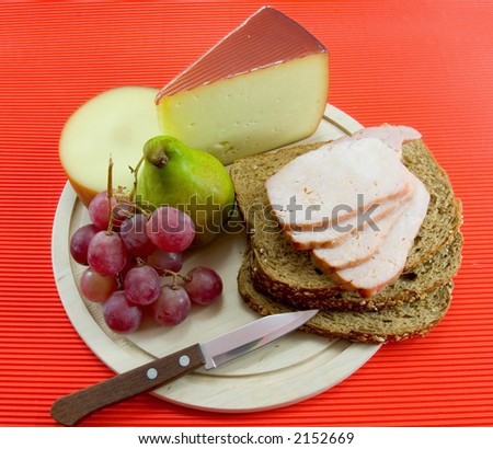 Wooden platter of flavorful cheeses and meat