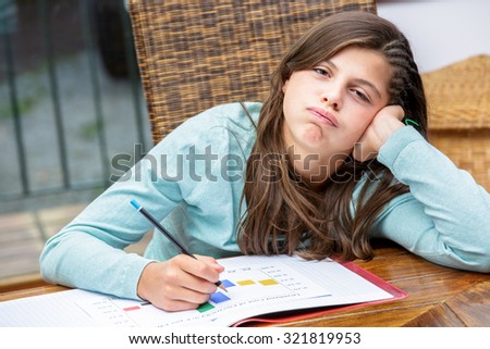 beautiful girl student doing her homework without motivation