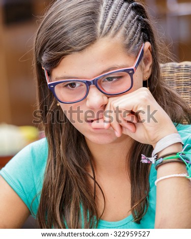 Portrait of attractive steessed teen girl trying to nail biting