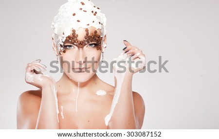 Portrait of beautiful girl with trendy make-up with coffee beans and cream