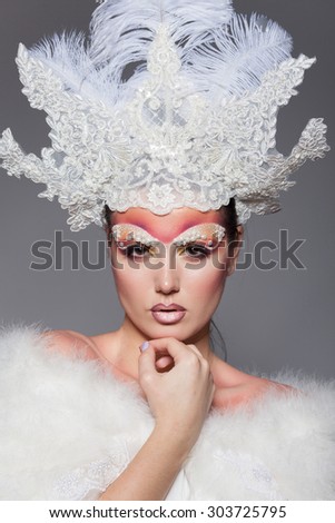 close-up studio portrait of a girl in a fur collar and crown of the Snow Queen