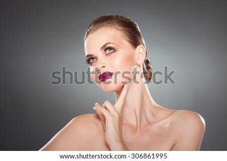 beautiful girl touches her face. close-up studio portrait. youth and health. skin care.