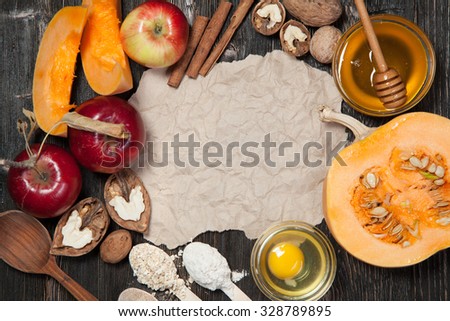 Ingredients for pumpkin and apple pie. Apples, nuts, pumpkin, honey, flour, eggs, oatmeal, sugar on vintage wooden background. Vintage paper with space for text. Recipe book.