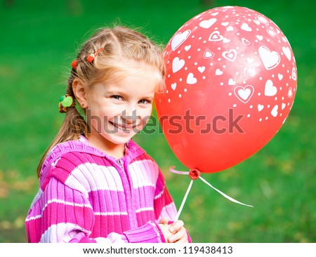 little girl with red balloon  in the park