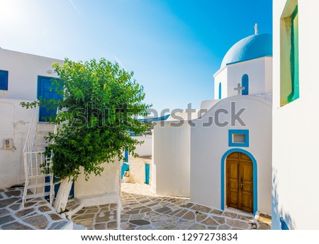 Typical whitewashed church with blue colored dome on the corner of the street, Lefkes, Paros island, Greece