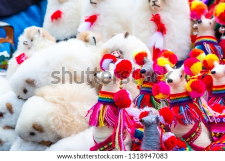 Fluffy white toy lama on the street souvenir shop in Peru