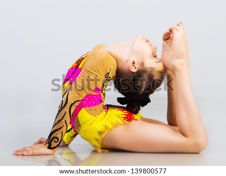 little girl gymnast on a light background