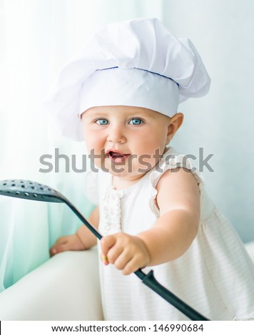 cute baby in chef\'s hat with kitchen tool