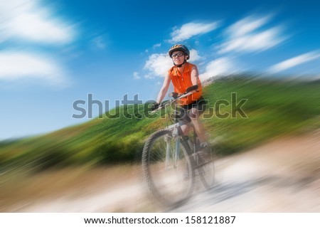 A young female riding a mountain bike outdoor with blur background