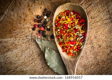 spices in a wooden spoon with laurel leaves on cutting board