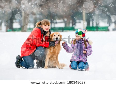 Happy family on a winter walk with the dog breed golden retriever