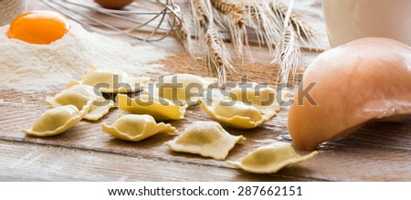 Ravioli and chicken breast on a flour board