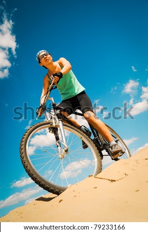 bikecyclist  in the desert against blue sky