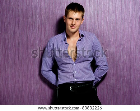 fashion man in shirt standing near the wall