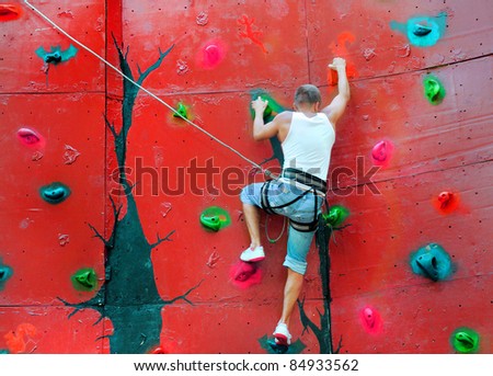 strong man climbing on a climbing wall training in insurance
