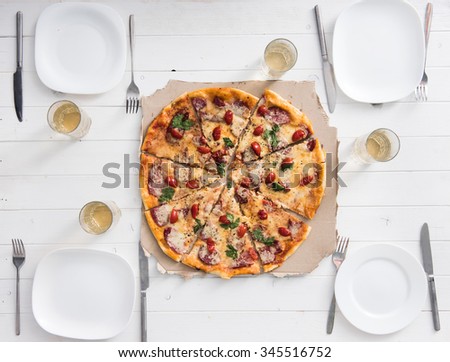 table with pizza set for four persons top view